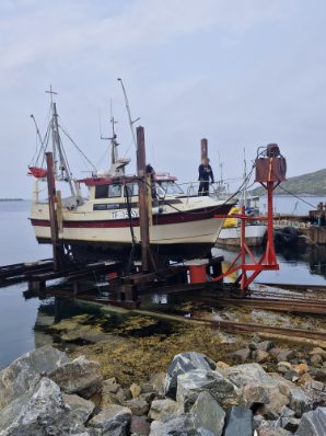 Fiskebåt på slippvognen ved sjøen