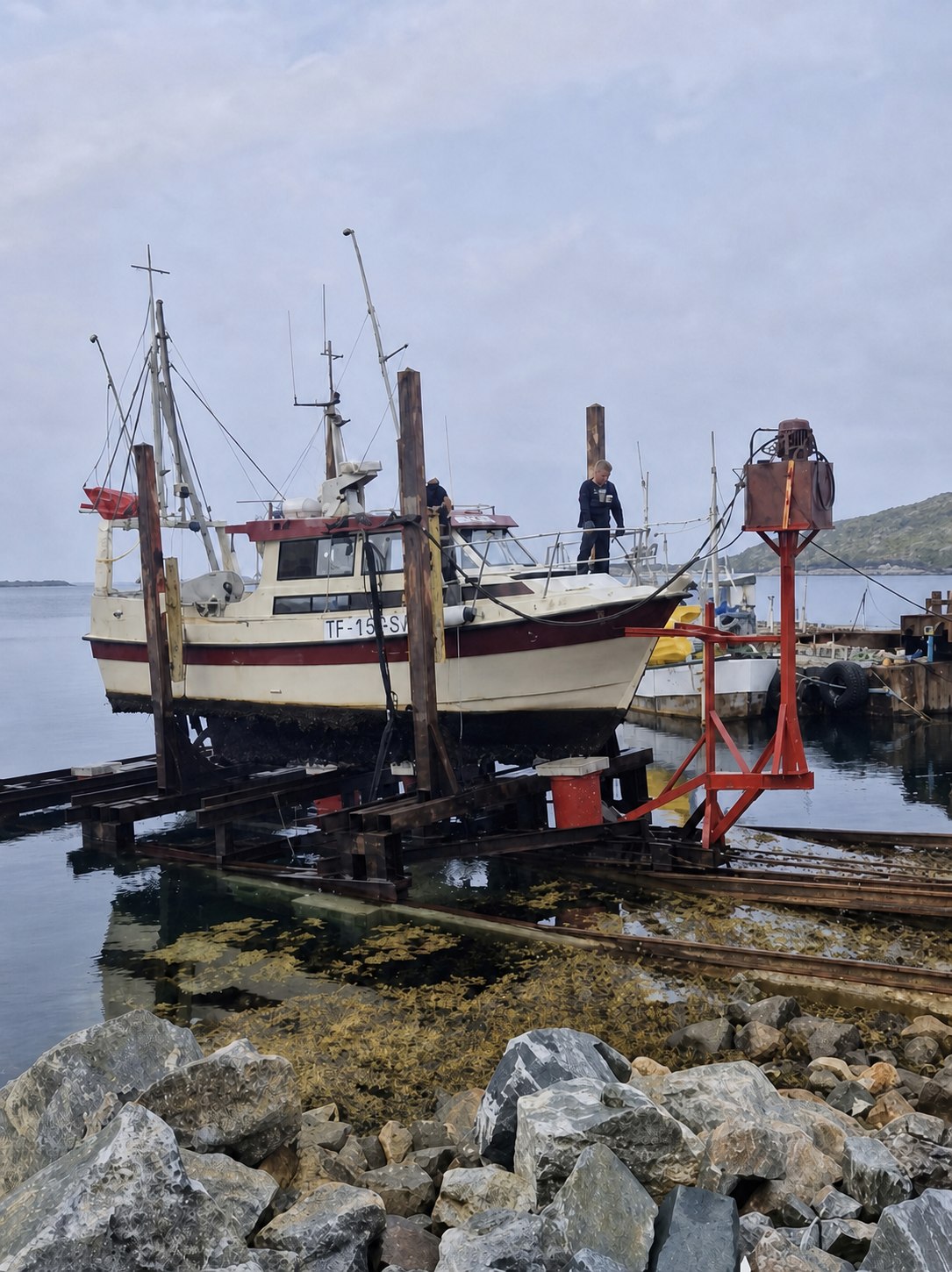 Fiskebåt TF-15-SV på slippvognen ved sjøen under det første opptrekket